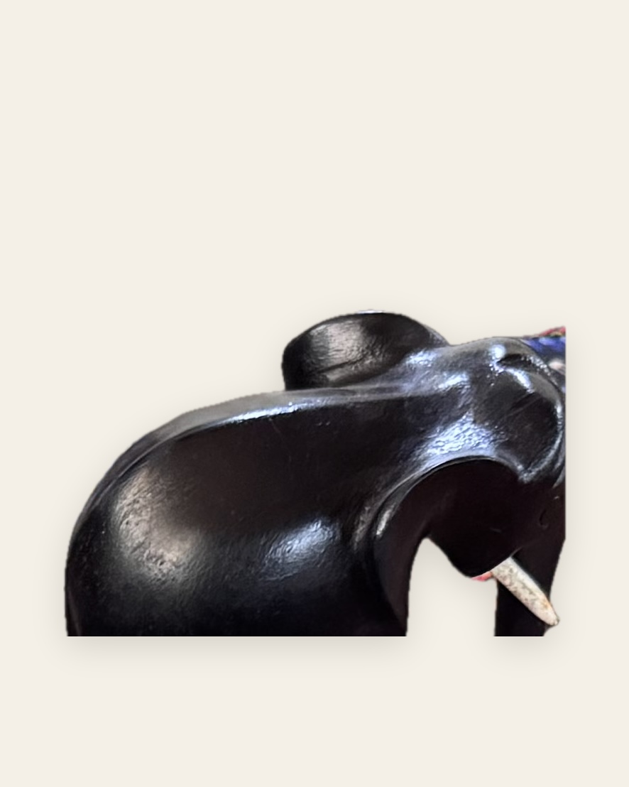 Éléphant sculpté dans un bois sombre et poli, vu de trois quarts