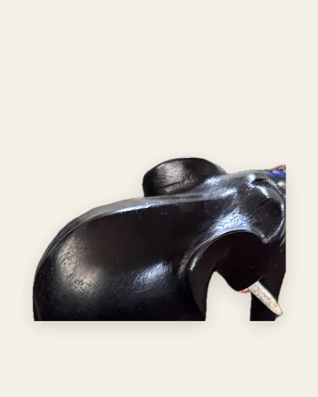 Éléphant sculpté dans un bois sombre et poli, vu de trois quarts