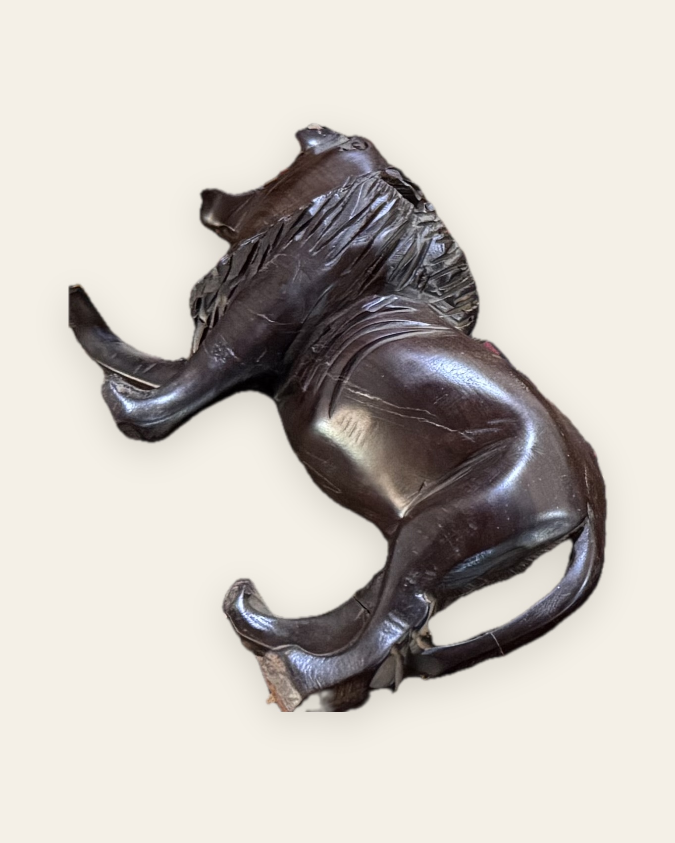 Félin sculpté en bois sombre, couché, vu de profil