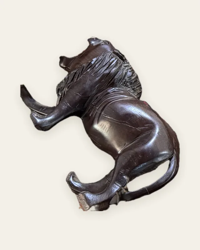Félin sculpté en bois sombre, couché, vu de profil