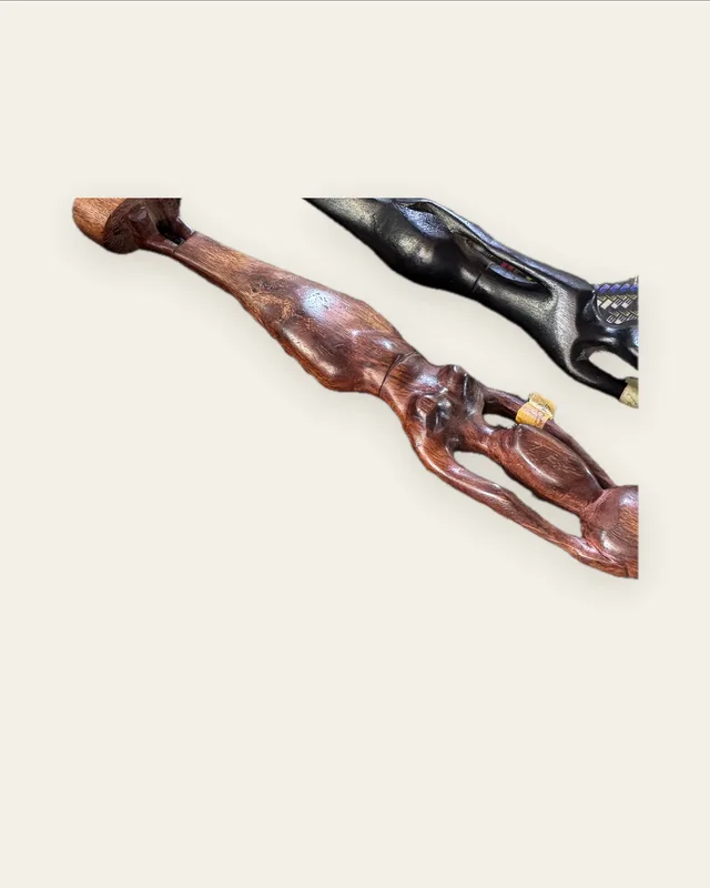 Figure allongée sculptée dans un bois brun-rouge aux veines apparentes